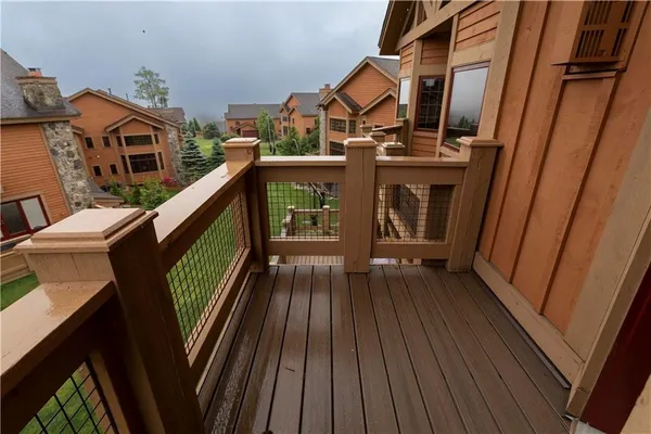 a view of a balcony with mountain view and wooden floor