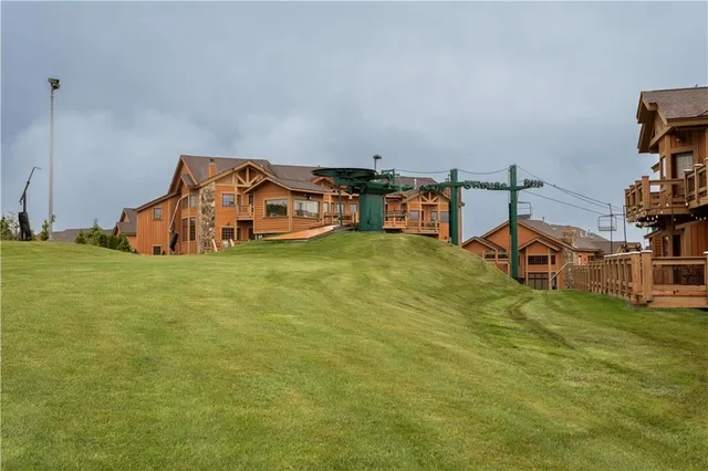 a view of a big house with a big yard and large trees