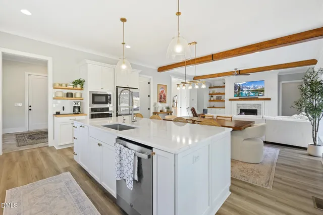 a dining room filled chandelier and wooden floor