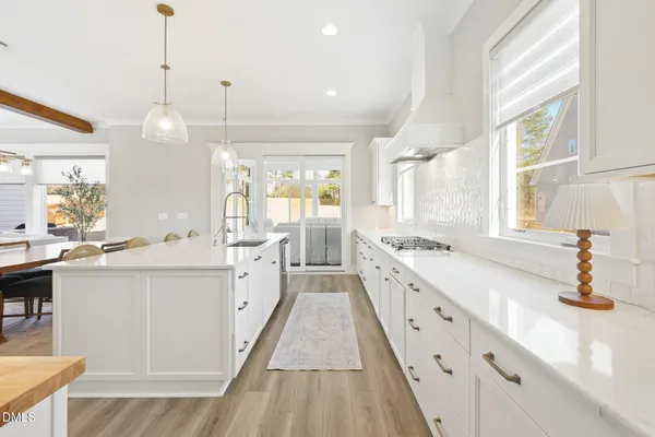 a kitchen with kitchen island granite countertop a sink cabinets and stainless steel appliances
