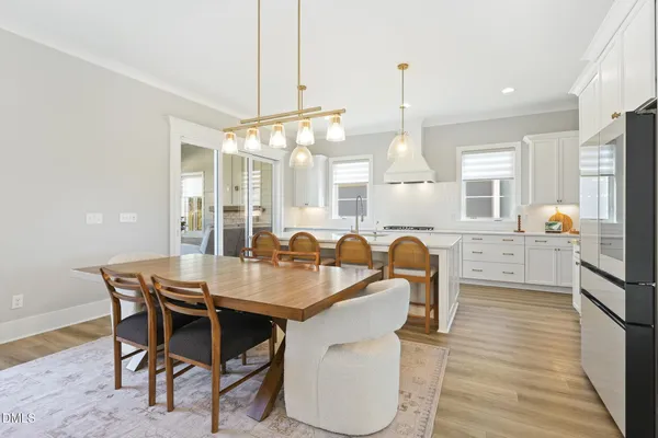 a dining room with furniture a chandelier and wooden floor