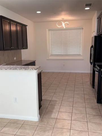 a kitchen with stainless steel appliances granite countertop a refrigerator and a stove