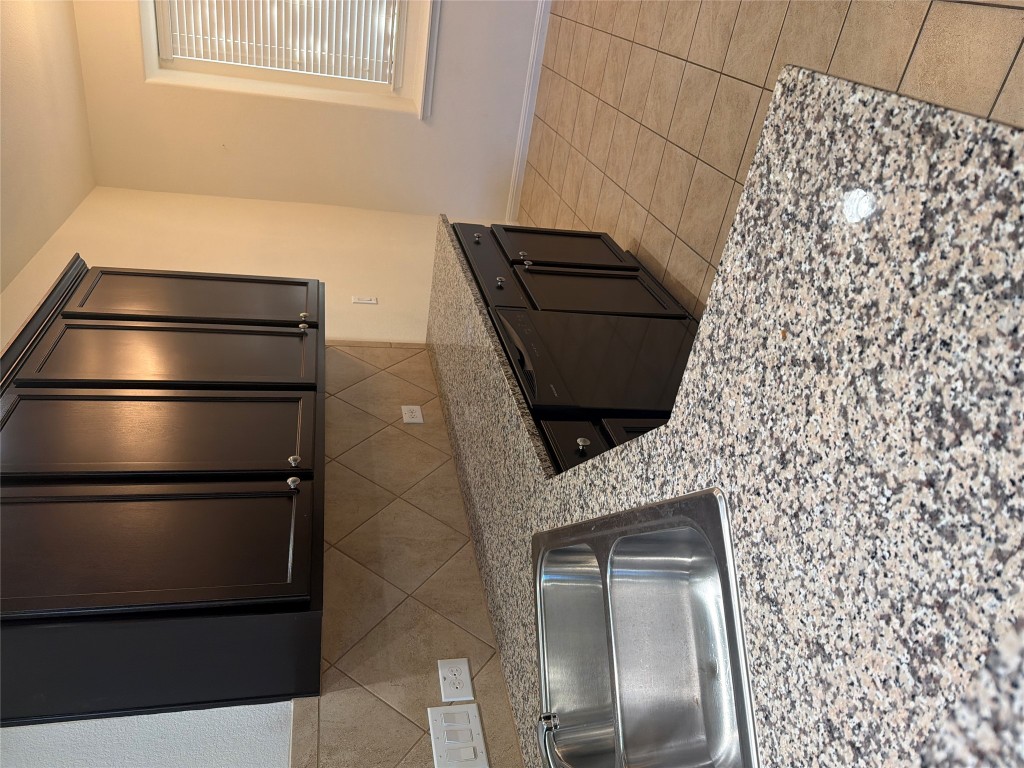 516 East Slaughter Lane, Unit 1404 Austin, TX 78744 - Photo 6 of 17 a kitchen with a sink a stove and cabinets