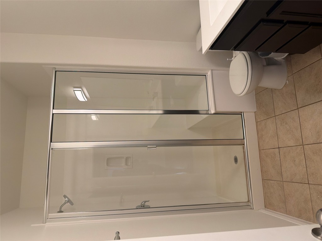 516 East Slaughter Lane, Unit 1404 Austin, TX 78744 - Photo 7 of 17 a bathroom with a toilet a sink and shower