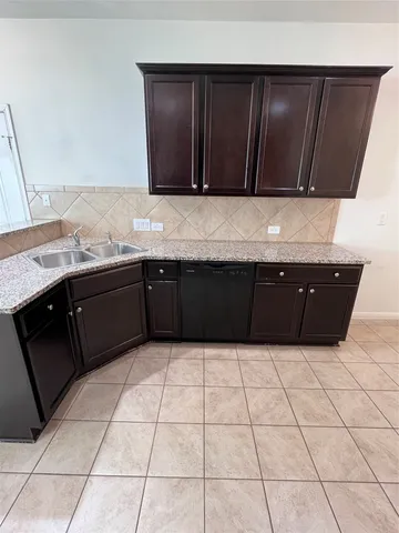 an empty room with chandelier fan and windows