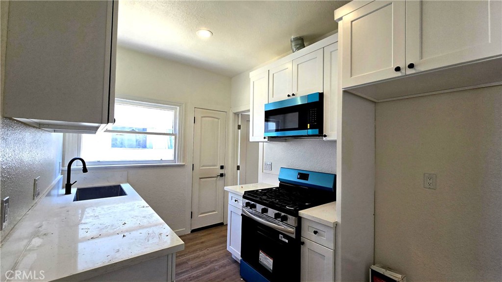 973 North Pk Circle, Unit 5 Long Beach, CA 90813 - Photo 4 of 9 a kitchen with stainless steel appliances granite countertop a stove and a sink