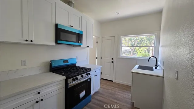 a kitchen with stainless steel appliances granite countertop a sink stove and microwave