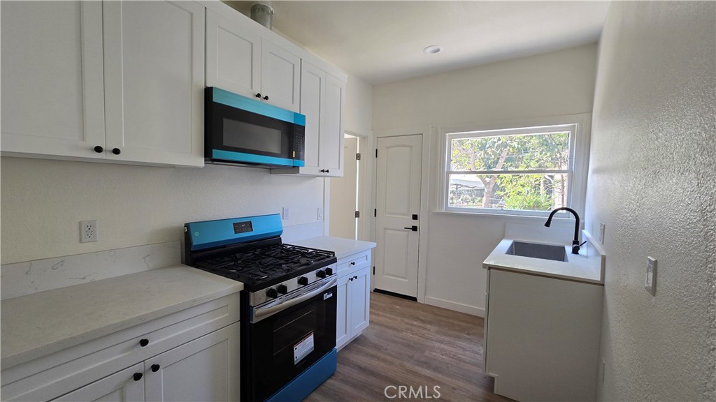 973 North Pk Circle, Unit 5 Long Beach, CA 90813 - Photo 9 of 9 a kitchen with stainless steel appliances granite countertop a sink stove and microwave