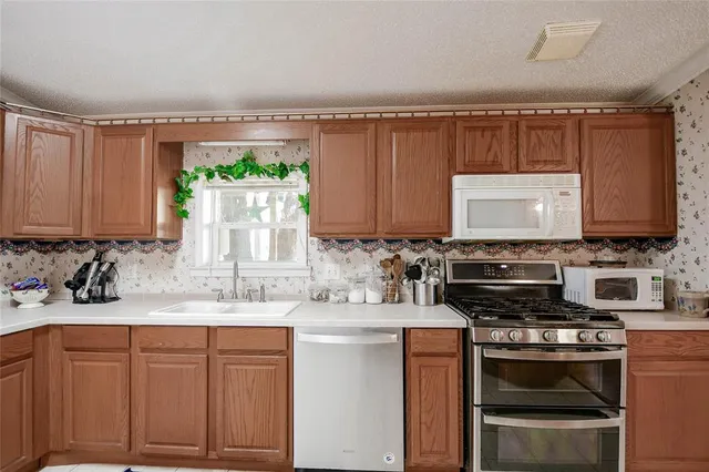 a kitchen with stainless steel appliances granite countertop a sink stove and cabinets