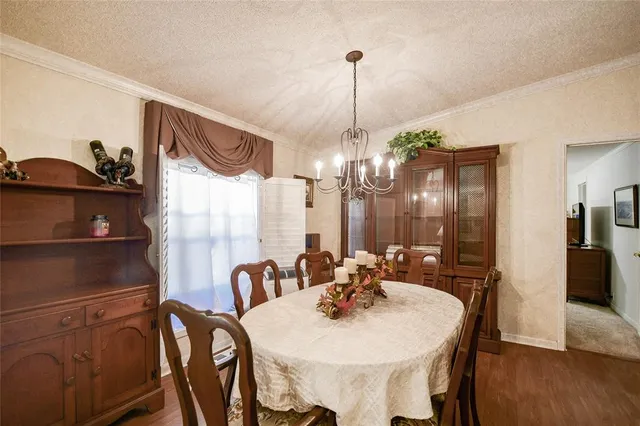 a view of a dining room and livingroom with furniture wooden floor a chandelier
