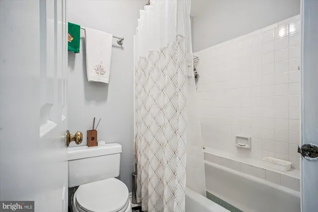 a white toilet sitting next to a bathroom sink and tub