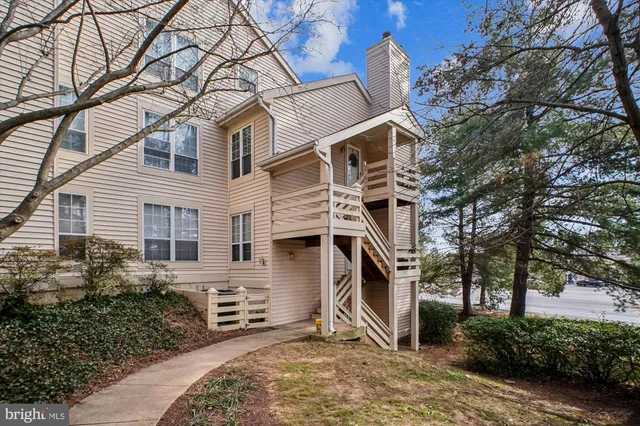 a view of a white house with a large tree and a yard