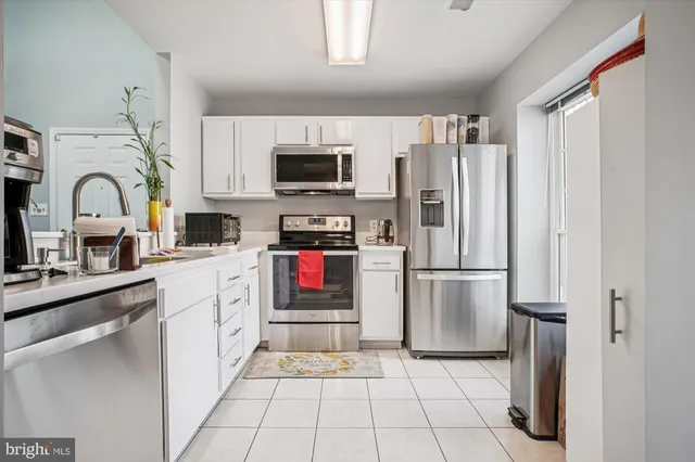 a kitchen with stainless steel appliances a refrigerator sink and microwave