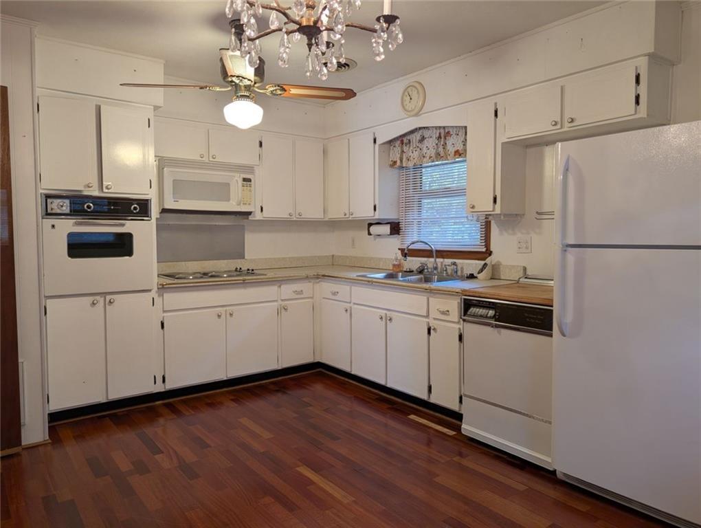 109 7th Street Carrollton, GA 30117 - Photo 4 of 19 a kitchen with cabinets wooden floor and stainless steel appliances