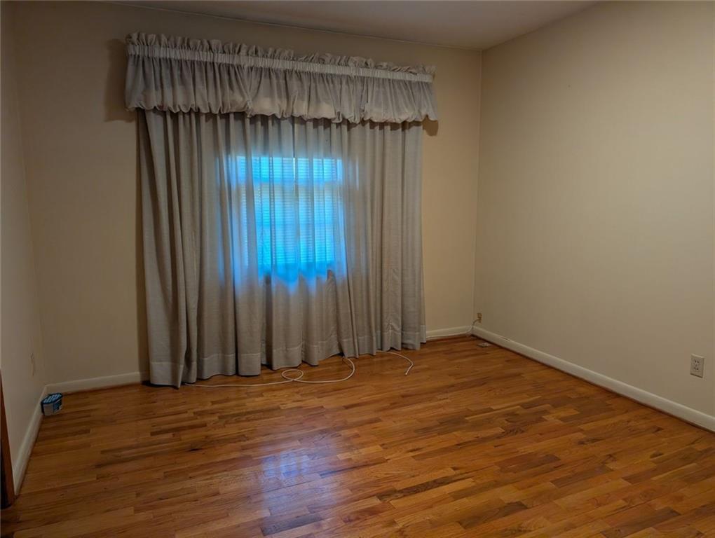 109 7th Street Carrollton, GA 30117 - Photo 8 of 19 an empty room with wooden floor and a window