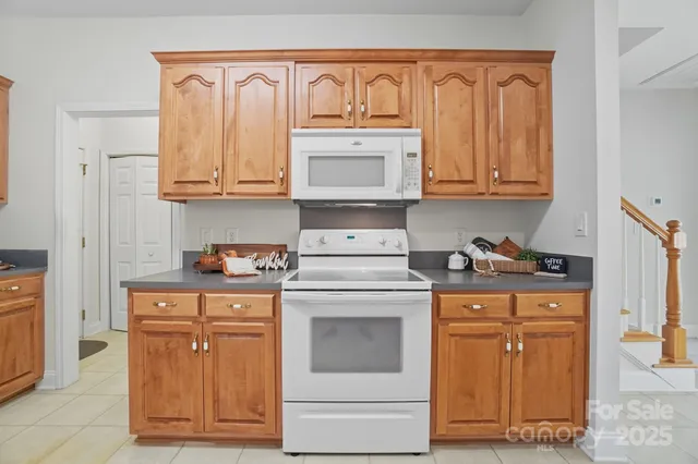 a large kitchen with stainless steel appliances granite countertop a refrigerator and a stove top oven