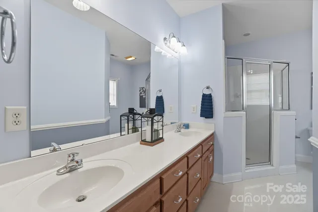 a bathroom with double vanity and a mirror