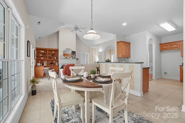 an empty room with chandelier fan and windows