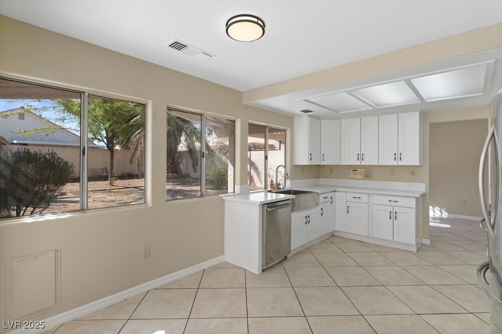 5309 West Camino Del Rancho Las Vegas, NV 89130 - Photo 13 of 41 Kitchen with white cabinets, light tile patterned floors, and stainless steel appliances