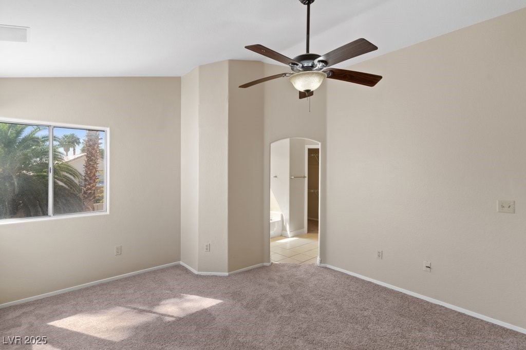 5309 West Camino Del Rancho Las Vegas, NV 89130 - Photo 27 of 41 Empty room with light carpet, high vaulted ceiling, a ceiling fan, and arched walkways