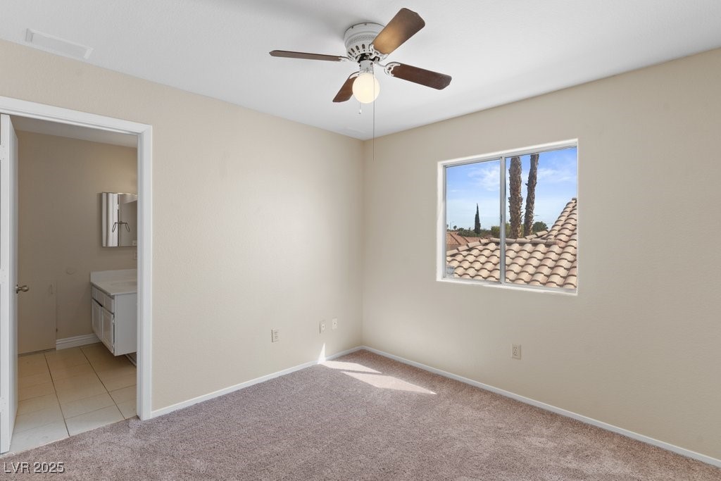 5309 West Camino Del Rancho Las Vegas, NV 89130 - Photo 29 of 41 Unfurnished bedroom with light carpet, ceiling fan, ensuite bath, and light tile patterned flooring