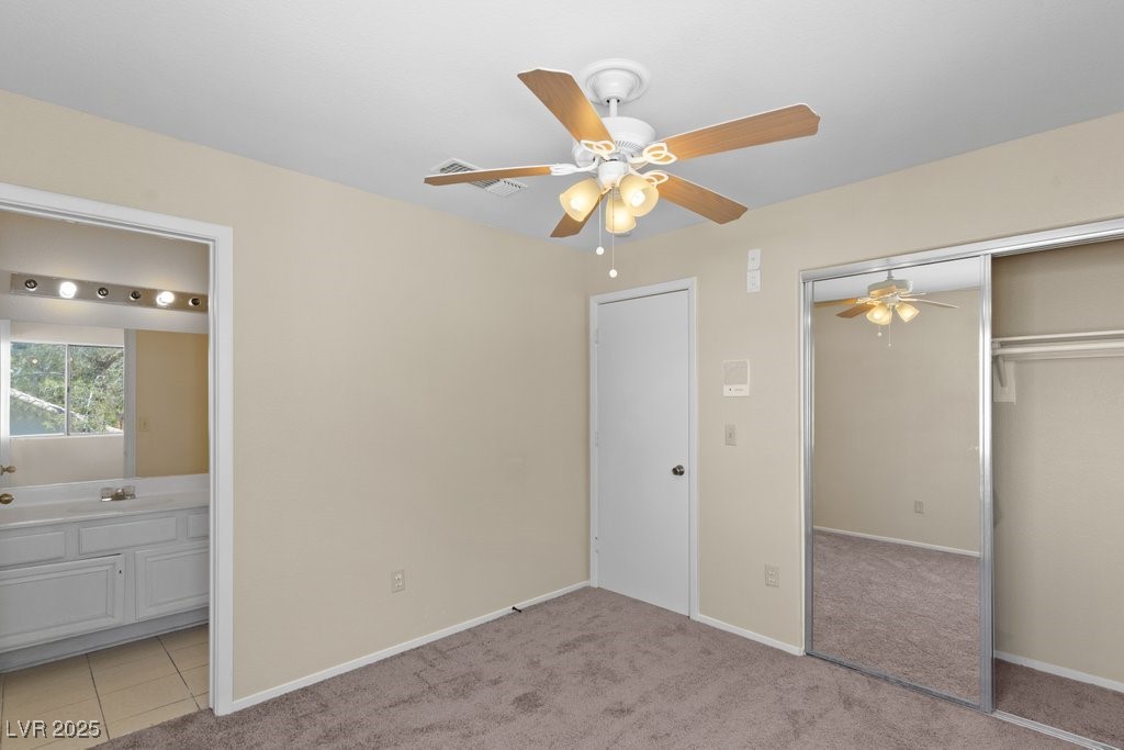 5309 West Camino Del Rancho Las Vegas, NV 89130 - Photo 33 of 41 Unfurnished bedroom featuring light colored carpet, ceiling fan, connected bathroom, and a closet