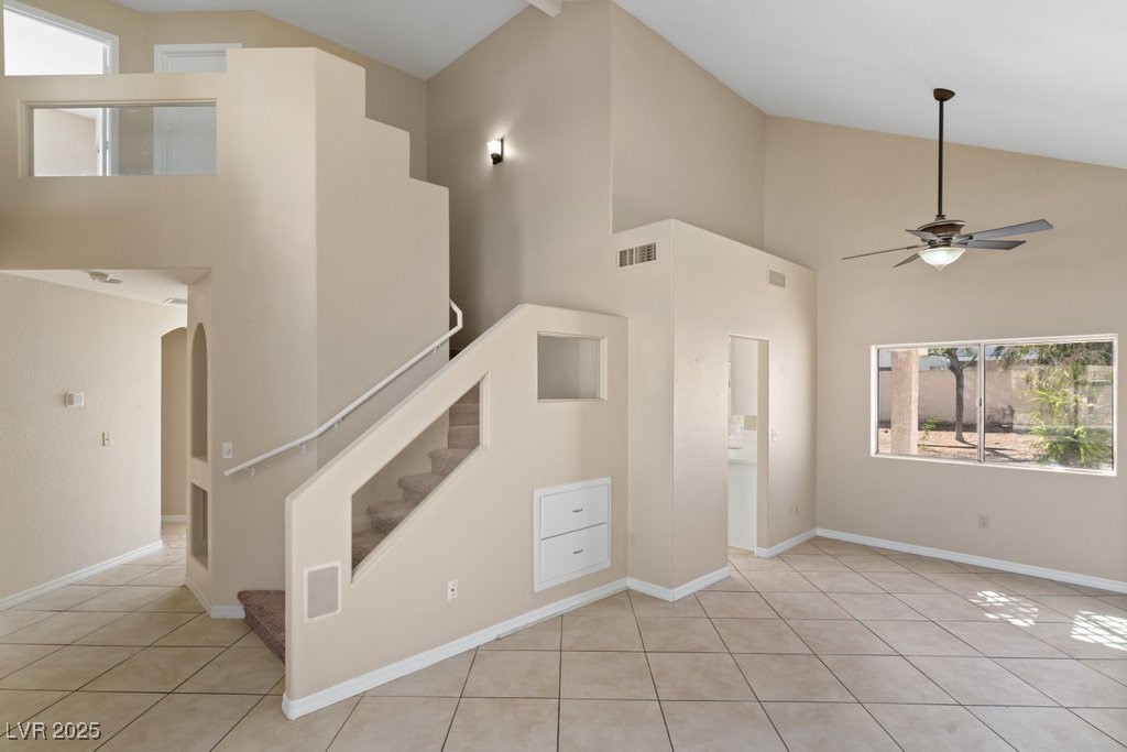 5309 West Camino Del Rancho Las Vegas, NV 89130 - Photo 7 of 41 Unfurnished living room with high vaulted ceiling, plenty of natural light, light tile patterned floors, and a ceiling fan
