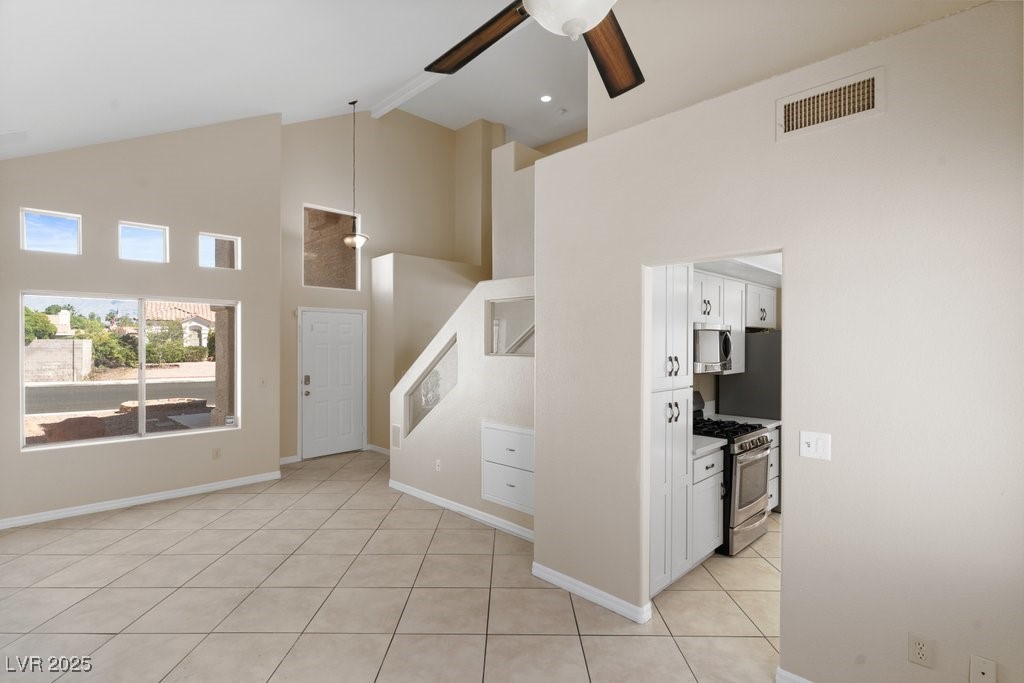 5309 West Camino Del Rancho Las Vegas, NV 89130 - Photo 8 of 41 Unfurnished living room with high vaulted ceiling, light tile patterned flooring, beam ceiling, and a ceiling fan