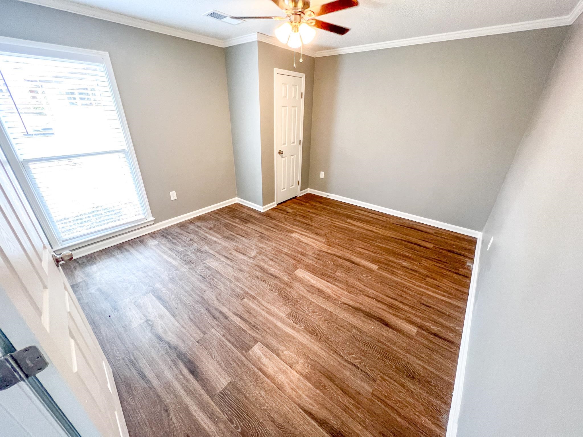 7108 Farmhouse Drive Memphis, TN 38125 - Photo 14 of 21 an empty room with wooden floor and windows