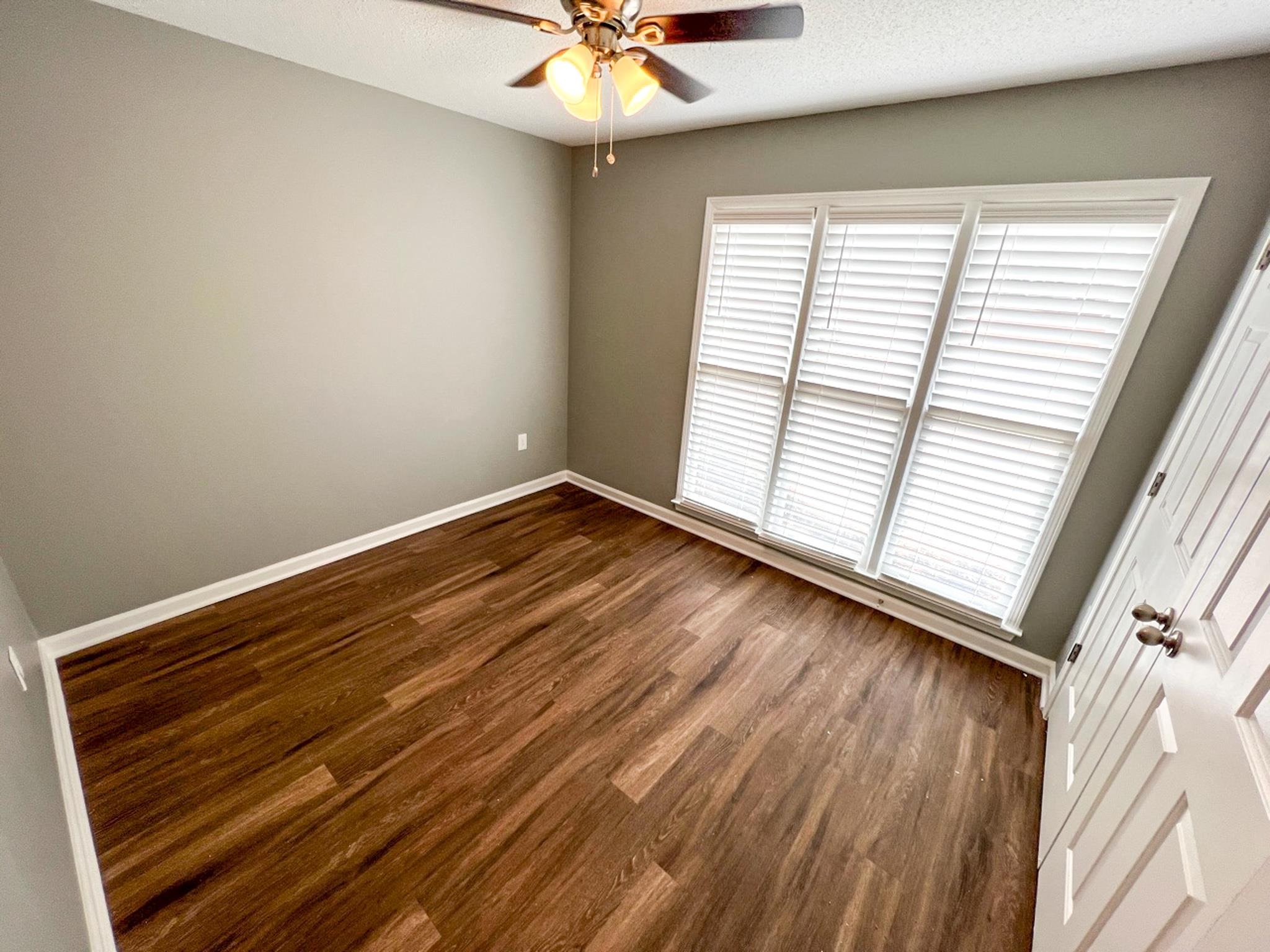 7108 Farmhouse Drive Memphis, TN 38125 - Photo 16 of 21 an empty room with wooden floor and windows