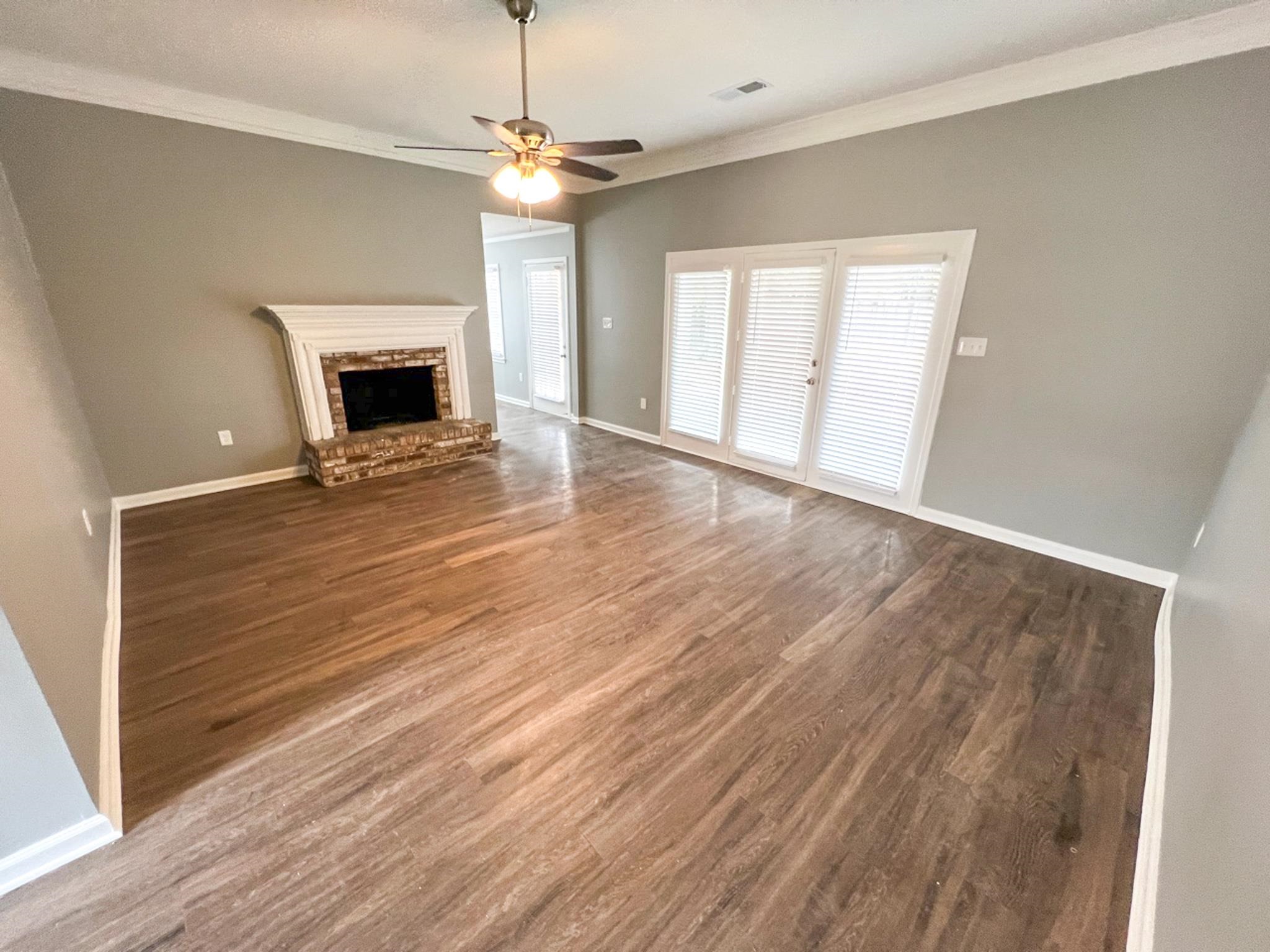 7108 Farmhouse Drive Memphis, TN 38125 - Photo 7 of 21 a view of an empty room with wooden floor fireplace and a window