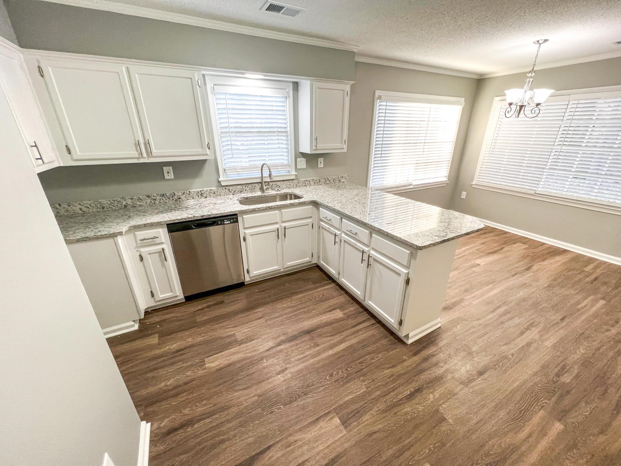 7108 Farmhouse Drive Memphis, TN 38125 - Photo 10 of 21 a kitchen with granite countertop white cabinets and a wooden floor