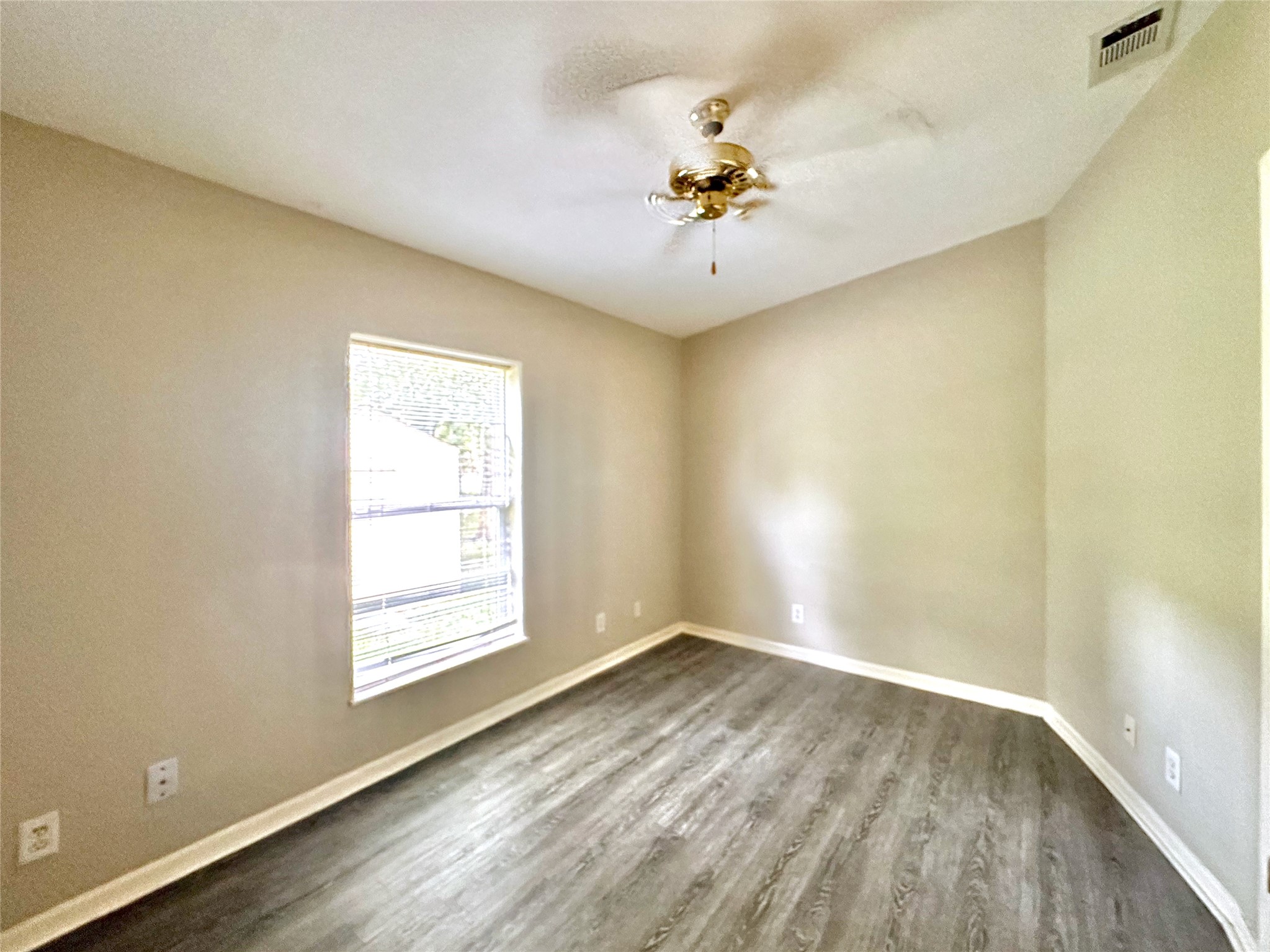 202 Main Street Fresno, TX 77545 - Photo 25 of 26 an empty room with a window and wooden floor