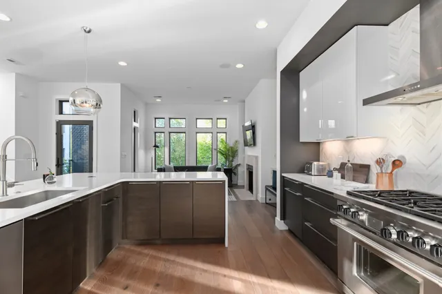 a large kitchen with stainless steel appliances lots of counter space and a sink