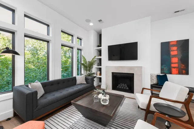 a living room with furniture a flat screen tv and a fireplace