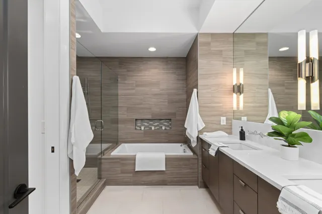 a bathroom with a tub sink and mirror