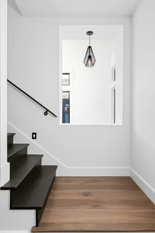 a view of a hallway with wooden floor and staircase