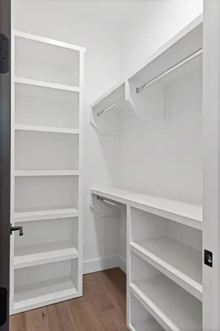 a view of walk in closet with empty racks