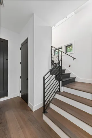 a view of a hallway with wooden floor and stairs