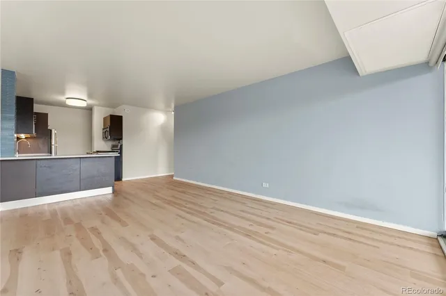 a view of a kitchen with wooden floor and a sink