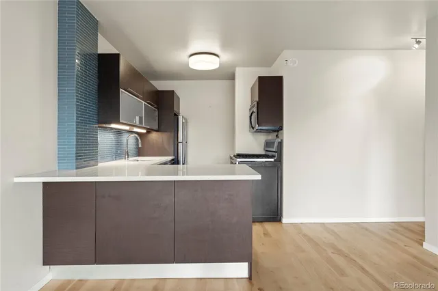 a view of kitchen with stainless steel appliances kitchen island sink and refrigerator