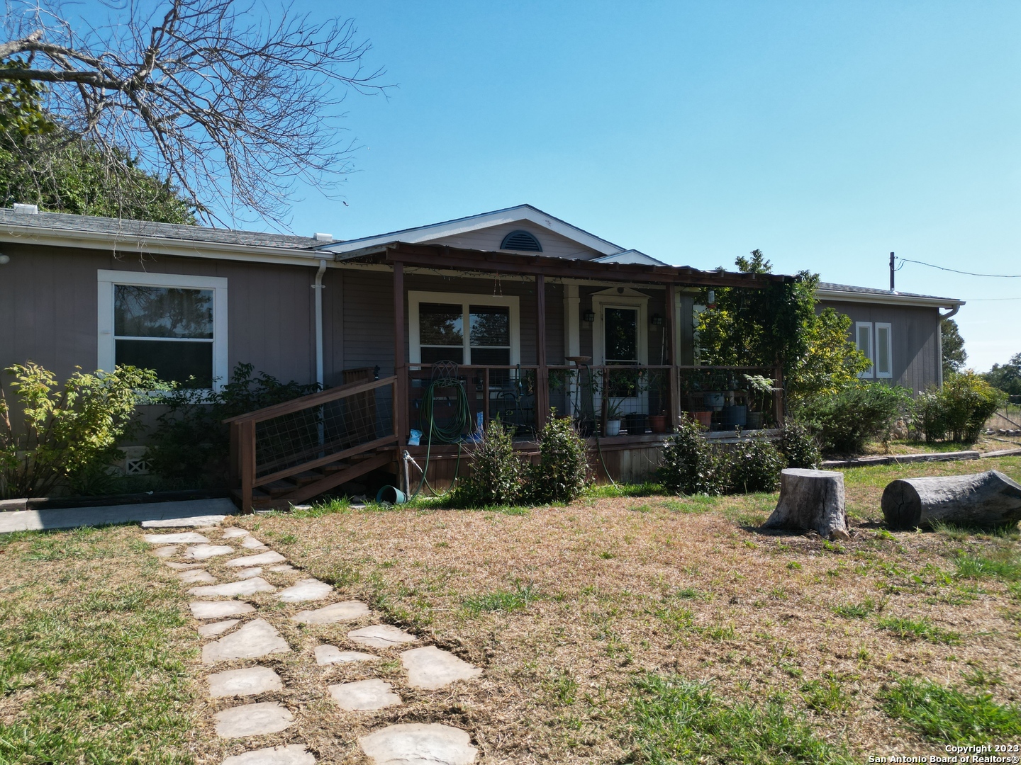 a view of house with backyard and glass windows