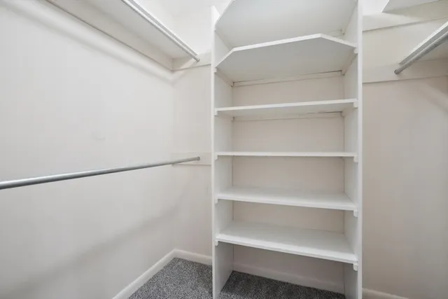 a bedroom with a bed next to a window and a dresser