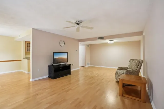 a view of a livingroom with a piano and wooden floor