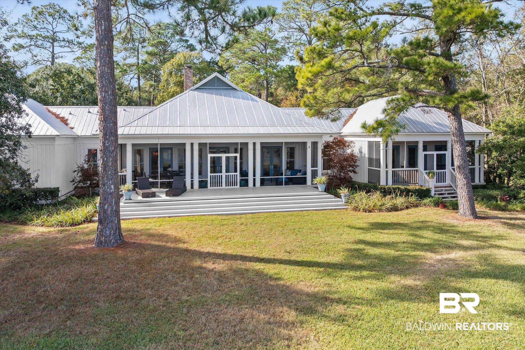 7015 Bay Road Mobile, AL 36605 - Photo 38 of 53 Back of property featuring a metal roof, a sunroom, and a lawn