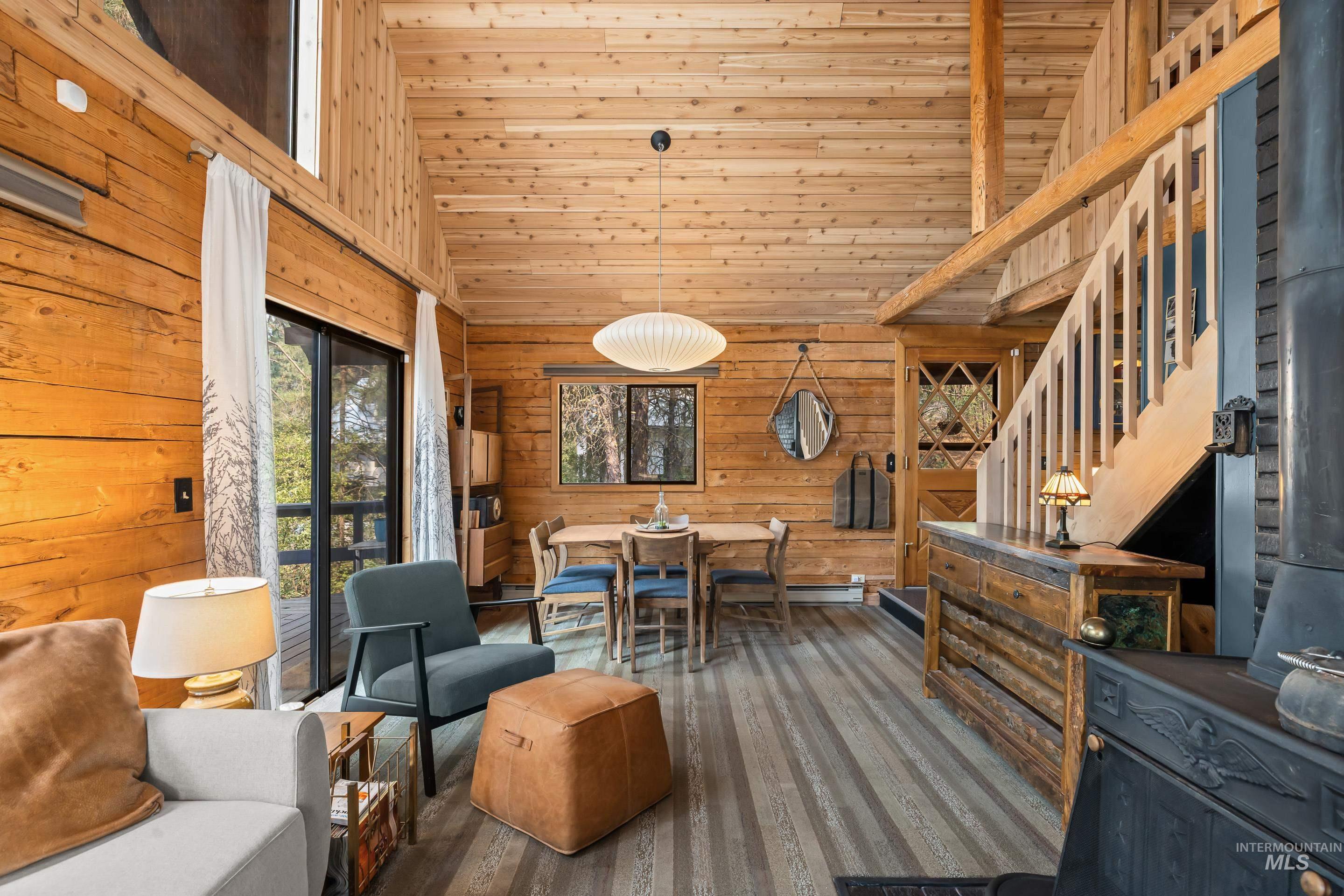 73 Rainbow Ridge Road Garden Valley, ID 83622 - Photo 29 of 49 Vaulted wood-paneled ceilings, wood-finish flooring, wood stove, built-in staircase, and sliding glass door