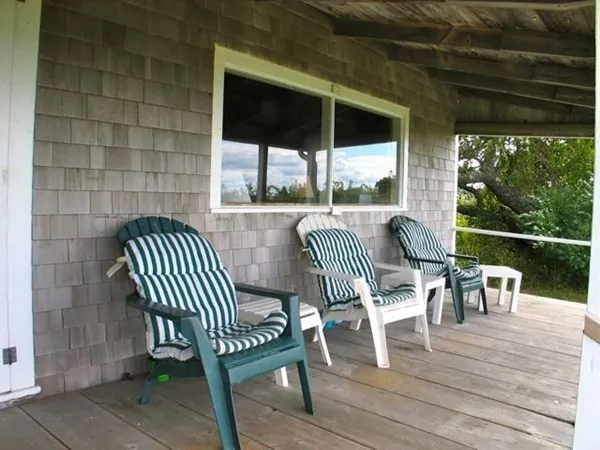 a view of a porch with furniture and a yard