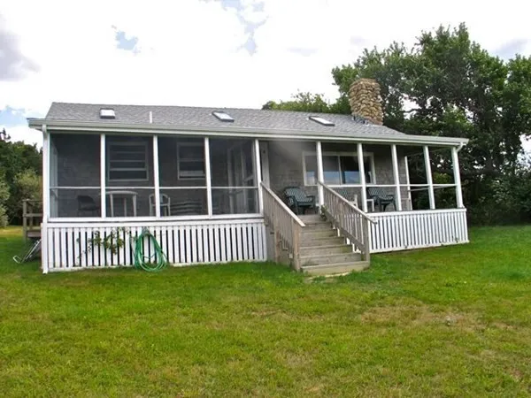 a view of a house with a deck and a yard
