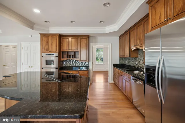 a large kitchen with stainless steel appliances granite countertop a refrigerator and a stove