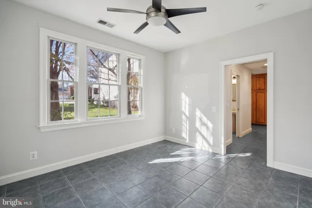 a view of empty room with windows and fan
